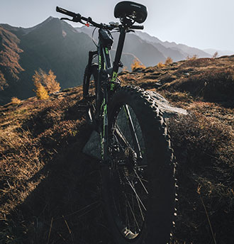 Mountain bike parked at summit of mountain peak.