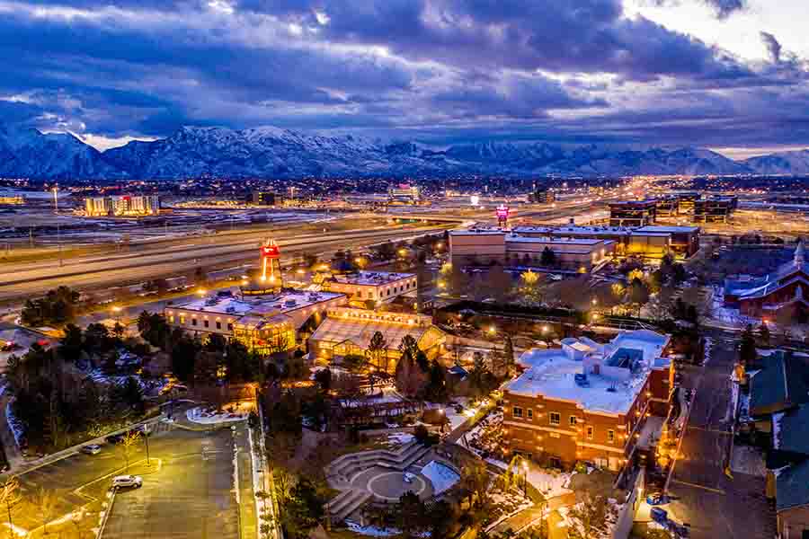 Aerial view of Lehi, Utah at night surrounded by towering snow capped peaks.