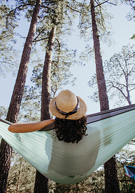 Woman sitting in hammock outside